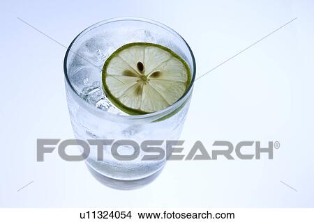 Picture - Close-up of a piece of lemon floating on a glass of water. Fotosearch