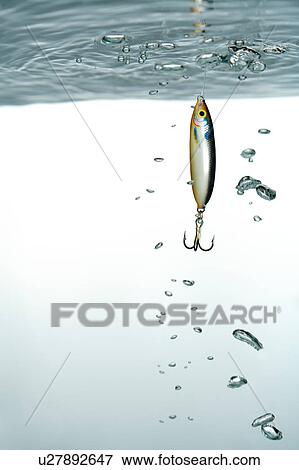 Stock Photo - Close-up of fishing hook in the water. Fotosearch