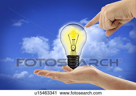 Clip Art - Human hand holding and pointing a bulb in background of clear sky. Fotosearch