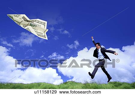 Stock Illustration - Man running on lawn and a paper plane flying in clear sky. Fotosearch