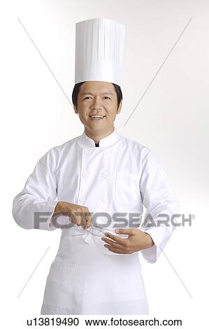 Stock Image - Chef holding a mixing bowl and smiling at the camera. Fotosearch