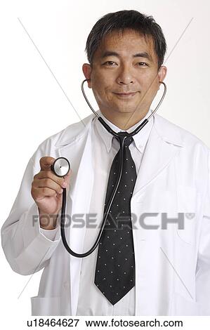 Doctor holding the stethoscope and smiling at the camera View Large Photo Image Stock Photo - Doctor holding the stethoscope and smiling at the camera. Fotosearch