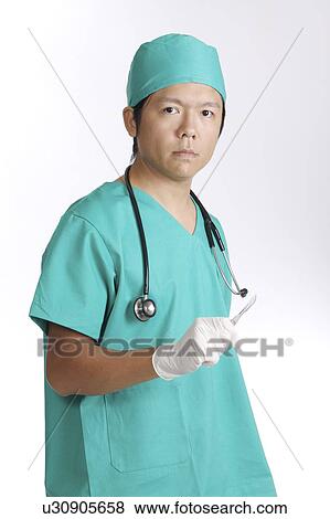 Doctor in operating gown with a scalpel in hand View Large Photo Image Stock Photo - Doctor in operating gown with a scalpel in hand. Fotosearch