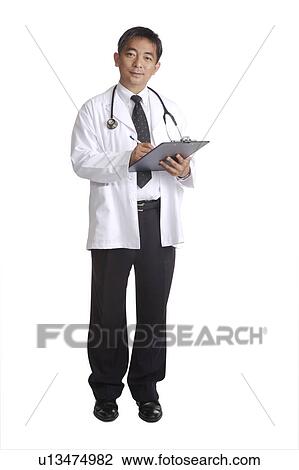 Doctor writing on the clipboard and looking at the camera View Large Photo Image Stock Image - Doctor writing on the clipboard and looking at the camera. Fotosearch