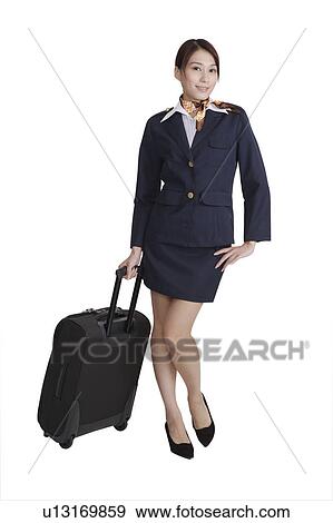 Stock Photo - Flight attendant holding a suitcase with one arm akimbo. Fotosearch