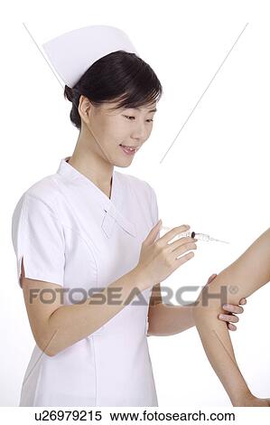 Stock Photography - Nurse giving an injection to a patient. Fotosearch