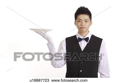 Waiter holding a plate for serving and looking at the camera View Large Photo Image Stock Image - Waiter holding a plate for serving and looking at the camera. Fotosearch