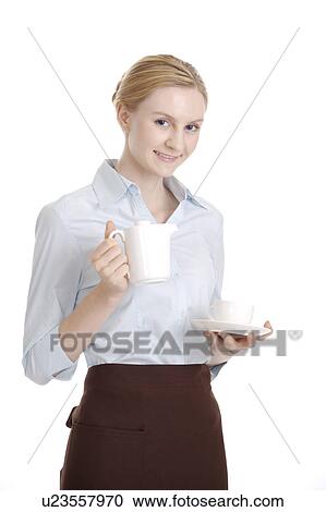 Waitress holding a teapot and a cup, smiling at the camera View Large Photo Image Stock Image - Waitress holding a teapot and a cup, smiling at the camera. Fotosearch