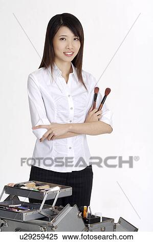 Young beautician holding the make-up brush and looking at the camera View Large Photo Image Stock Photography - Young beautician holding the make-up brush and looking at the camera. Fotosearch