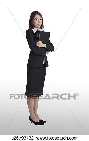 Young business woman holding documents, looking at the camera View Large Photo Image Stock Image - Young business woman holding documents, looking at the camera. Fotosearch