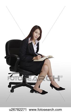 Young business woman sitting on the chair and looking at the camera View Large Photo Image Stock Image - Young business woman sitting on the chair and looking at the camera. Fotosearch