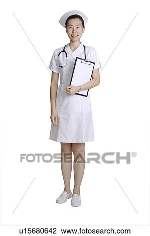 Stock Image - Young nurse holding the clipboard and looking at the camera. Fotosearch