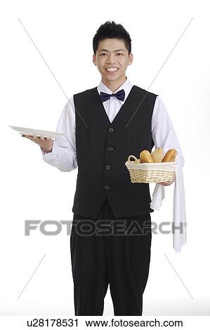 Young waiter holding a basket of bread and a plate, smiling at the camera View Large Photo Image Stock Image - Young waiter holding a basket of bread and a plate, smiling at the camera. Fotosearch