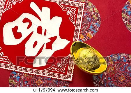 Picture - Close-up of a gold ingot and Chinese character. Fotosearch