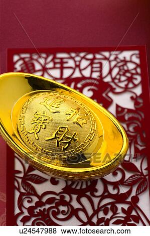 Stock Photo - Close-up of a gold ingot on the decoupage with Chinese characters. Fotosearch