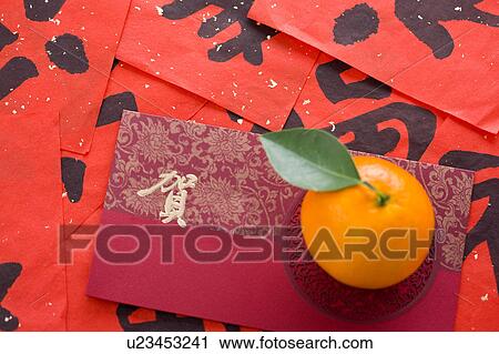 Stock Image - Close-up of an orange on a card of celebrating Chinese New Year. Fotosearch