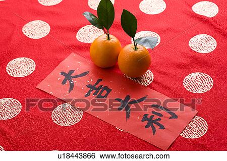 Stock Photograph - Close-up of two oranges and a Chinese couplet. Fotosearch