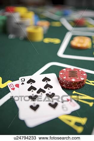 Stock Image - Gambling chips by playing cards. Fotosearch