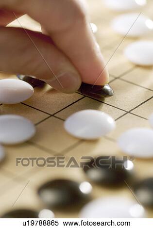 Man playing Go at Go board View Large Photo Image Stock Photography - Man playing Go at Go board. Fotosearch