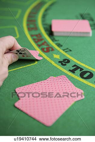 Picture - Man playing poker, looking at cards, close-up, rear view. Fotosearch