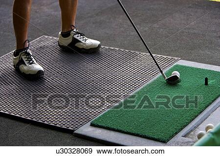 A man hitting golf balls at a driving range View Large Photo Image Stock Photo - A man hitting golf balls at a driving range. Fotosearch