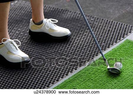 A woman hitting golf balls at a driving range View Large Photo Image Stock Image - A woman hitting golf balls at a driving range. Fotosearch