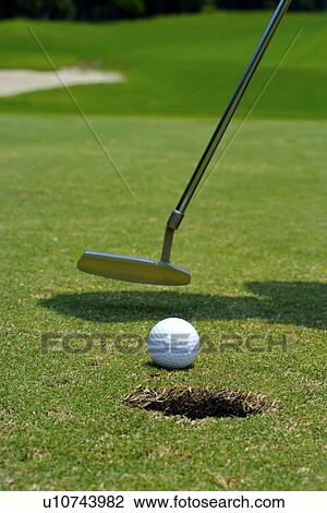 Golf ball and putter on edge of hole, close up View Large Photo Image Stock Image - Golf ball and putter on edge of hole, close up. Fotosearch