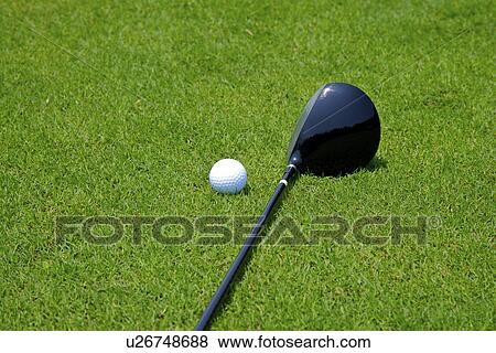 Stock Photo - Golf club and golf ball, ground view, close up. Fotosearch