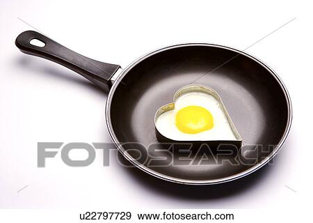 Heart shaped fried egg on pan View Large Photo Image Stock Photo - Heart shaped fried egg on pan. Fotosearch