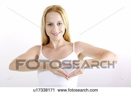 Young woman making heart-shaped gesture View Large Photo Image Stock Image - Young woman making heart-shaped gesture. Fotosearch