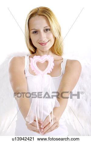 Young woman wearing angel wings holding magic wand, smiling, portrait View Large Photo Image Stock Image - Young woman wearing angel wings holding magic wand, smiling, portrait. Fotosearch