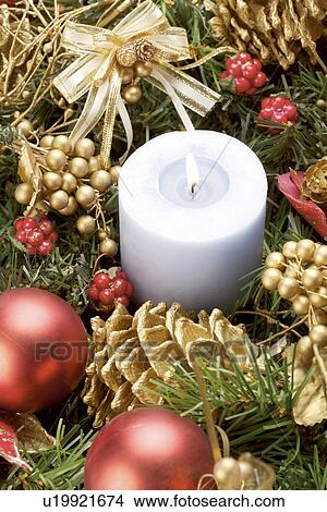Picture - Candle surrounded by Christmas ornament. Fotosearch