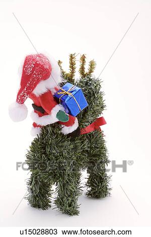 Stock Image - Santa Claus driving plastic deer. Fotosearch