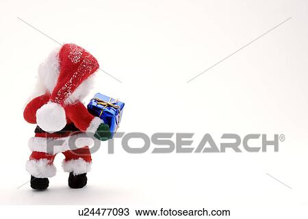 Stock Image - Santa Claus figurine with gift, rear view. Fotosearch