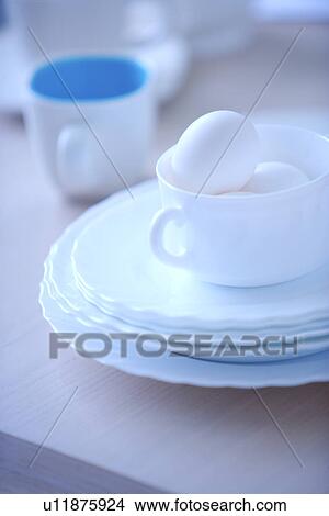 Picture - Eggs in cup and plates on table. Fotosearch