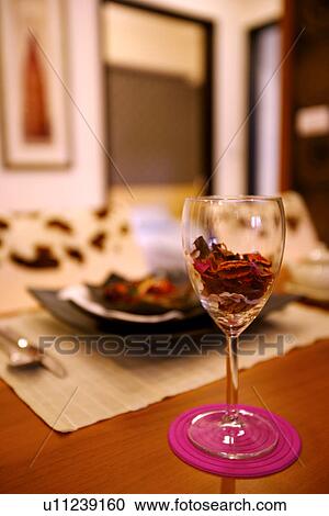 Stock Image - Place setting on table, wineglass on the foreground. Fotosearch