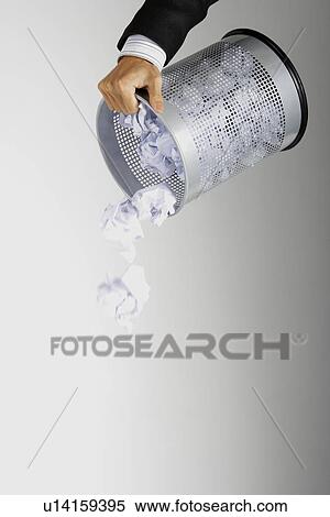 Stock Photography - Man emptying wastebasket, focus on hands. Fotosearch