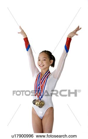 Girl in tracksuit wearing gold medals, arms raised View Large Photo Image Stock Photograph - Girl in tracksuit wearing gold medals, arms raised. Fotosearch