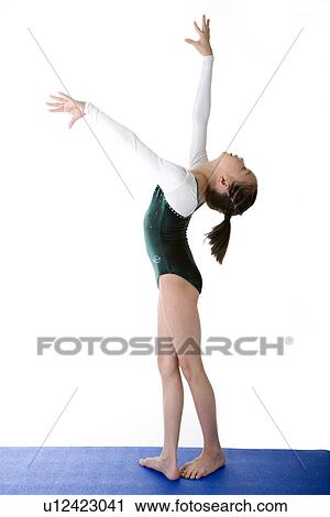 Stock Image - Girl practicing gymnastic pose on pad, side view. Fotosearch