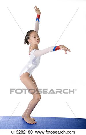 Girl practicing gymnastic pose on pad View Large Photo Image Stock Image - Girl practicing gymnastic pose on pad. Fotosearch