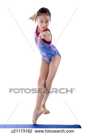 Girl practicing gymnastic pose on pad View Large Photo Image Stock Image - Girl practicing gymnastic pose on pad. Fotosearch