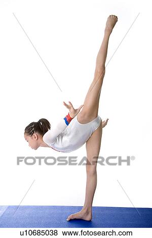 Girl practicing gymnastic pose on pad, side view View Large Photo Image Stock Photo - Girl practicing gymnastic pose on pad, side view. Fotosearch