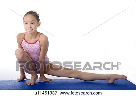 Girl practicing gymnastic pose on pad View Large Photo Image Stock Photo - Girl practicing gymnastic pose on pad. Fotosearch