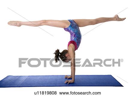 Girl practicing gymnastic pose on pad View Large Photo Image Stock Photo - Girl practicing gymnastic pose on pad. Fotosearch