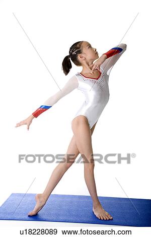 Girl practicing gymnastic pose on pad View Large Photo Image Stock Photo - Girl practicing gymnastic pose on pad. Fotosearch