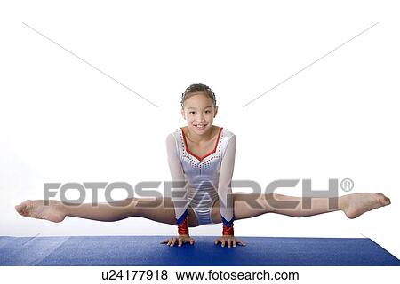 Girl practicing gymnastic pose on pad View Large Photo Image Stock Photo - Girl practicing gymnastic pose on pad. Fotosearch