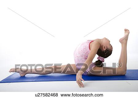 Girl practicing gymnastic pose on pad, side view View Large Photo Image Stock Photo - Girl practicing gymnastic pose on pad, side view. Fotosearch