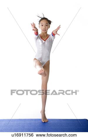 Girl practicing gymnastic pose on pad View Large Photo Image Stock Photograph - Girl practicing gymnastic pose on pad. Fotosearch