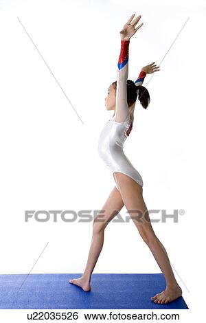 Girl practicing gymnastic pose on pad, side view View Large Photo Image Stock Photograph - Girl practicing gymnastic pose on pad, side view. Fotosearch