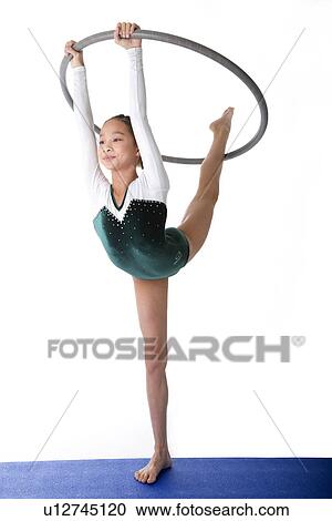 Girl practicing gymnastic pose with hoop on pad View Large Photo Image Stock Image - Girl practicing gymnastic pose with hoop on pad. Fotosearch